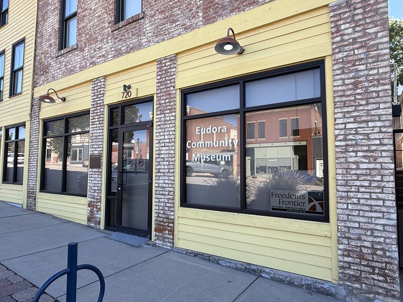 The Eudora Community Museum on Main Street, a yellow and white brick storefront with the museum name painted on its front window