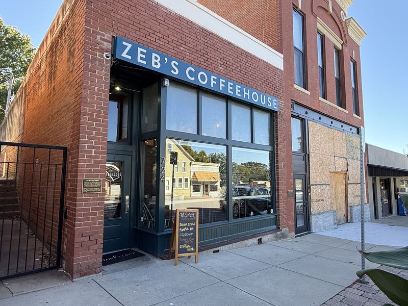 Zeb's Coffeehouse on Main Street: a red brick corner building with a blue Zeb's Coffeehouse sign over big front windows and a chalkboard sign on the sidewalk